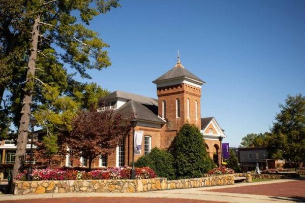 a large brick building with a steeple and a cross on top